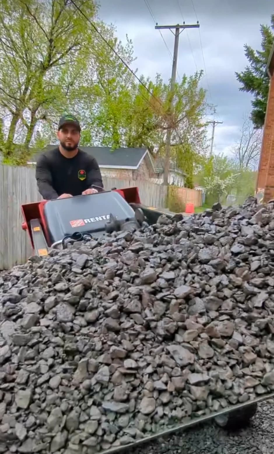 Adel operating a motorized aggregate power buggy transporting crushed stone and river rock on site
